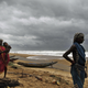 Fisherwomen watch the sea waves before evacuating the place near Podampeta village, on the outskirts of Gopalpur beach in Ganjam district, 140 kilometers (87 miles) south of Bhubaneswar.